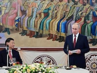 Chinese President Xi Jinping watches as Russian President Vladimir Putin speaks at a reception.