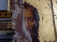 A damaged gilt Orthodox painting of Jesus Christ stands against a wall, as Ukrainians clear away debris after a Russian missile struck the historic Holy Transfiguration.