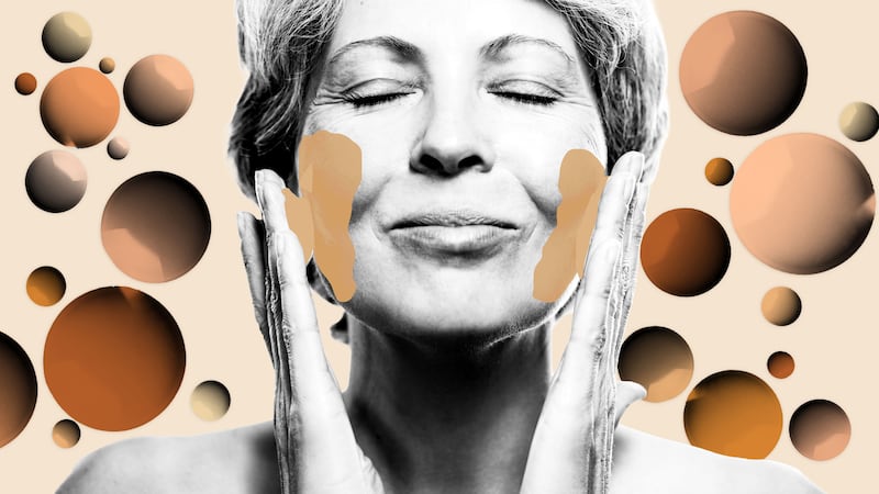 Older woman putting on foundation with foundation drops behind her