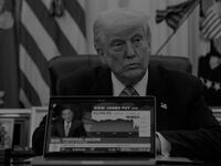 US President Donald Trump plays a CNBC news clip on a laptop