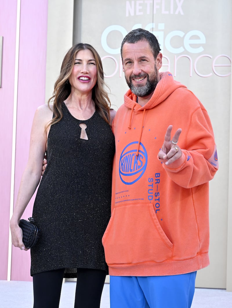 Jackie Sandler and Adam Sandler wear contrasting outfits as they attend the world premiere of Netflix's "Office Romance" in 2026.