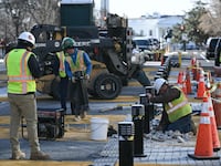 Crews remove light fixtures as they begin work removing the "Black Lives Matter" street mural and plaza in Washington, DC, on March 10, 2025.