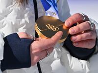 CORTINA D'AMPEZZO, ITALY - FEBRUARY 08: A close-up view of a gold medal held by Breezy Johnson of Team United States during the medal ceremony during the Women's Downhill on day two of the Milano Cortina 2026 Winter Olympics at Tofane Alpine Skiing Centre on February 08, 2026 in Cortina d'Ampezzo, Italy. (Photo by Mattia Ozbot/Getty Images)