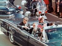 US President John F Kennedy, First Lady Jacqueline Kennedy, Texas Governor John Connally, and others smile at the crowds lining their motorcade route in Dallas, Texas, on November 22, 1963.