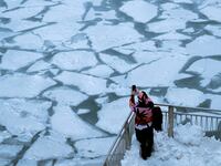 pedestrian stopping by chicago river to take picture of ice polar vortex frost quake frostquake steven battaglia climate change