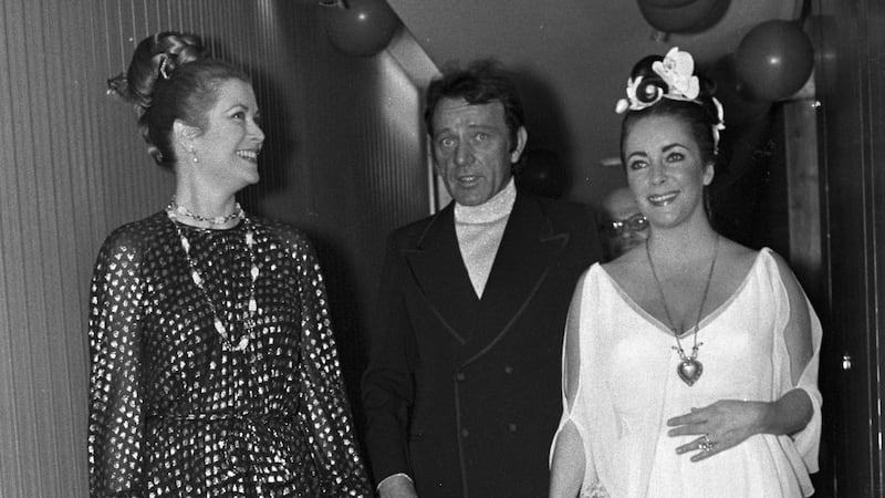Grace Kelly, Richard Burton, and Elizabeth Taylor celebrate Taylor's fortieth birthday.
Taylor wears the "Taj Mahal" diamond necklace.