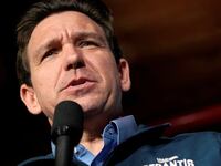 Ron DeSantis speaks at an Iowa campaign event with a microphone in hand.