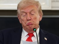 President Donald Trump reads a note in the State Dining Room of the White House on October 08, 2025 in Washington, DC.