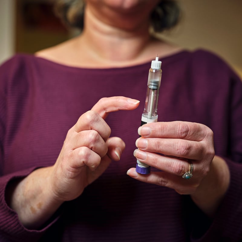 Woman holding a GLP-1 shot of Ozempic