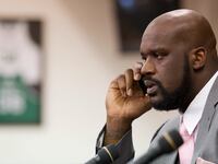 Shaquille O'Neal takes a phone call while announcing his retirement from the National Basketball Association (NBA) during a news conference at his home in Windermere, Florida June 3, 2011.