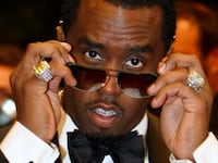 Sean “Diddy” Combs poses with his sunglasses slightly lowered.