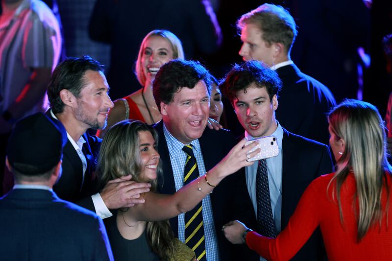 WEST PALM BEACH, FLORIDA - NOVEMBER 05: Tucker Carlson (C) poses for a selfie with supporters an election night watch party for Republican presidential nominee, former U.S. President Donald Trump at the Palm Beach Convention Center on November 05, 2024 in West Palm Beach, Florida. Americans cast their ballots today in the presidential race between Republican nominee former President Donald Trump and Vice President Kamala Harris, as well as multiple state elections that will determine the balance of power in Congress. (Photo by Joe Raedle/Getty Images)