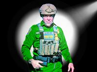 A photo illustration of Border Patrol Cmdr. Gregory Bovino in a spotlight.