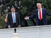 U.S. President Donald Trump gestures while answering questions from reporters as he tours the roof of the West Wing of the White House