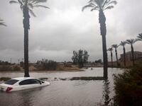 A white sedan is inundated with water after Tropical Storm Hilary struck Cathedral City, California.