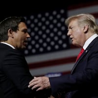 U.S. President Donald Trump talks with Republican Florida governor candidate Ron DeSantis during a Make America Great Again Rally at the Florida State Fairgrounds in Tampa, Florida, U.S., July 31, 2018.