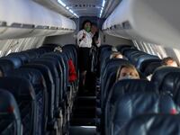 Flight attendants talk in a nearly empty cabin