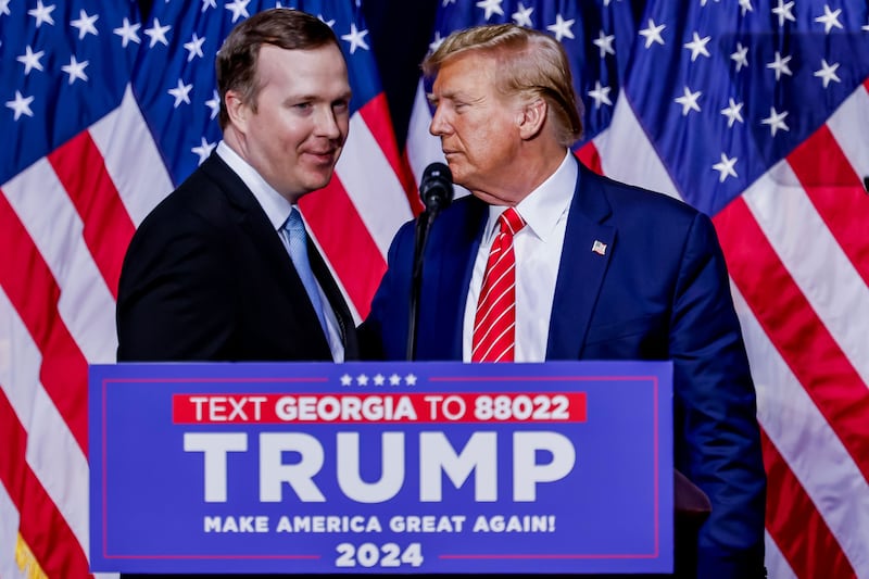 Brian Jack with Donald Trump in front of American flags and behind a lectern marked Georgia