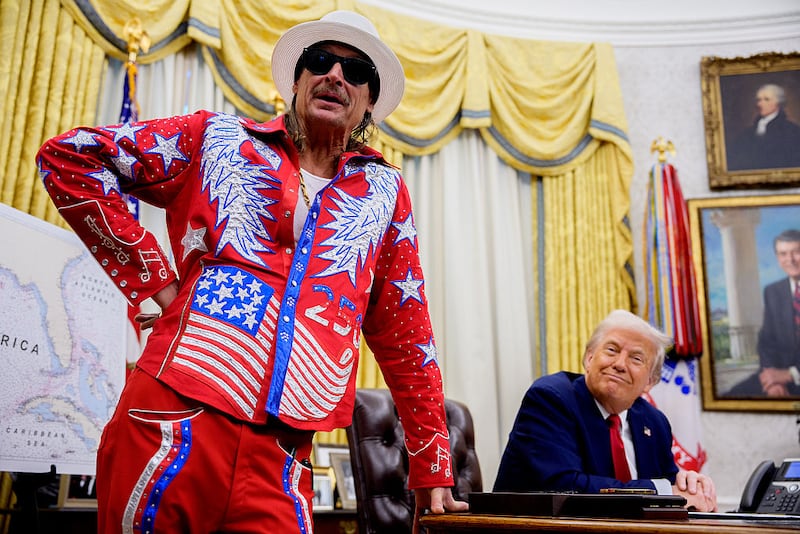 U.S. President Donald Trump listens as entertainer Kid Rock speaks during an executive order signing event in the Oval Office of the White House on March 31, 2025.