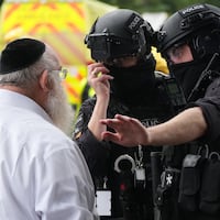 MANCHESTER, ENGLAND - OCTOBER 2: Members of the public and congregants seen as Police and other emergency responders attend the Heaton Park Hebrew Congregation Synagogue, where multiple were injured after stabbing and car attack on Yom Kippur, on October 2, 2025 in the Crumpsall suburb of Manchester, England. Greater Manchester Police said they were called to the scene shortly after 9:30 AM, when a witness said the assailant drove a car at people and then stabbed someone. Police then shot the suspected attacker. (Photo by Christopher Furlong/Getty Images)