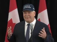 Doug Ford poses in a "Canada is not for sale" hat.