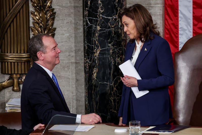 U.S. Vice President Kamala Harris speaks with U.S. Representative Adam Schiff. She is on the Speaker's dais in the House