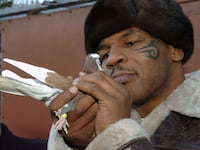 WALSALL, UNITED KINGDOM - NOVEMBER 18: Former world heavyweight boxing champion Mike Tyson meets up with a pigeon fancier Horace Potts (L), of Bloxwich, Walsall, West Midlands on November 18, 2005 in Walsall, England. Tyson who is well known for his love of pigeons dropped in to the home of pigeon fancier Horace Watts whilst on route to Birmingham, England, for a hotel dinner boxing event. (Photo by Stringer/Getty Images)