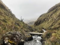 A photograph of a stream and bridge along the Inca trail near Llaviucu Lake.