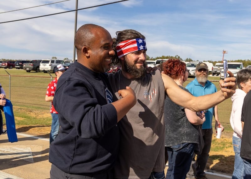Mississippi Democratic Senate candidate Scott Colom takes a selfie with an attendee waiting in line outside Trump's rally.