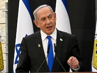 Israeli Prime Minister Benjamin Netanyahu gives a speech before flags.