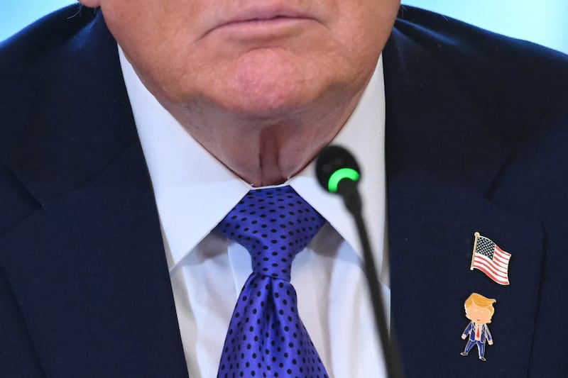 A detail of US President Donald Trump's pins are seen during a meeting with US oil companies executives in the East Room of the White House in Washington, DC on January 9, 2026. President Trump is aiming to convince oil executives to support his plans in Venezuela, a country whose energy resources he says he expects to control for years to come. US forces seized Venezuelan president Nicolas Maduro in a sweeping military operation on January 3, with Trump making no secret that control of Venezuela's oil was at the heart of his actions. (Photo by SAUL LOEB / AFP via Getty Images)
