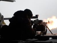 An Ukrainian Right Sector batallion volunteer fires a machine gun on January 3, 2015 from his position near the eastern Ukrainian village of Pisky, in the northeastern Donetsk region, at pro-Russian separatists near the Donetsk airport.