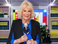 Queen Camilla holds a Barbie doll in her image during a reception to celebrate International Women's Day and mark the end of the Women of the World (WOW) Girls Festival Bus tour at Buckingham Palace on March 12, 2024.
