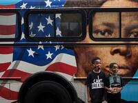 TOPSHOT - People walk by a bus with a mural of US abolitionist and former slave Harriet Tubman on it, as they arrive to attend the public viewing for George Floyd at the Fountain of Praise church in Houston, Texas on June 8, 2020.