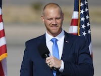 Daniel Rodimer speaks on stage at an outdoor campaign event.