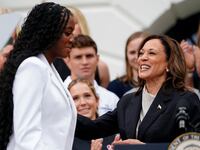 Vice President Kamala Harris standing at a podium with a student.