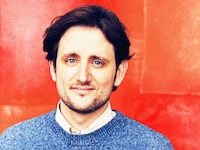 Photo illustration of Zach Woods on an orange and red background