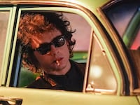 Timothee Chalamet is seen on location leaning out of a car window smoking a cigarette for the Bob Dylan biopic titled 'A Complete Unknown'