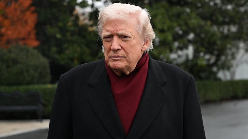 US President Donald Trump listens while taking questions from the press before boarding Marine One on the South Lawn of the White House in Washington, DC, on November 22, 2025 as he heads to visit The Courses at Joint Base Andrews, Maryland. (Photo by Alex WROBLEWSKI / AFP via Getty Images)