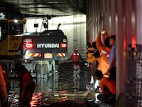 Rescue teams work at a flooded tunnel in Cheongju, South Korea, where at least 13 people died after becoming trapped by flooding.