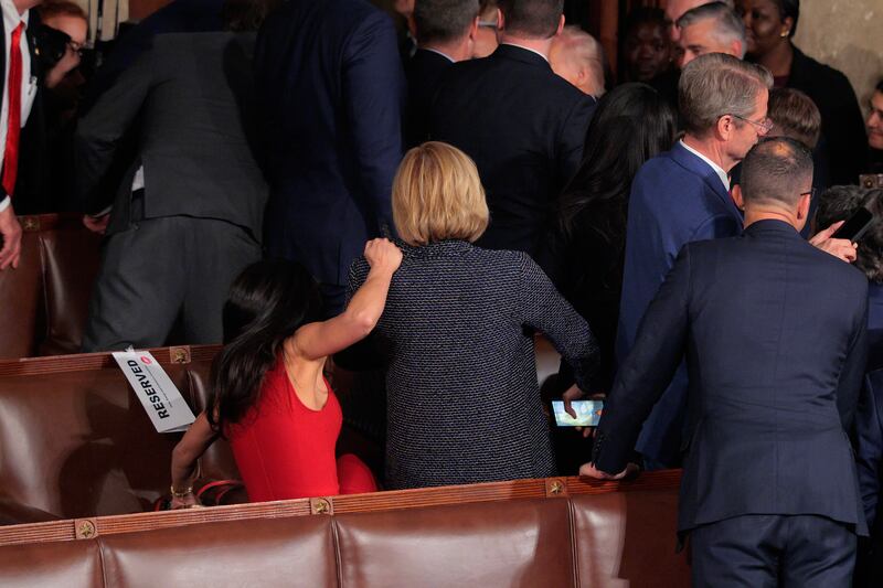 Boebert grabs onto New York Rep. Claudia Tenney as she falls off of the seat she was standing in to watch Trump leave the Capitol after his State of the Union address.