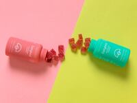 Two bottles of Earlybird CBD gummies on a pink and yellow background.