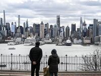 A view of the New York City skyline from across the Hudson River, with people standing at the water’s edge, shortly after an earthquake occurred on Friday.
