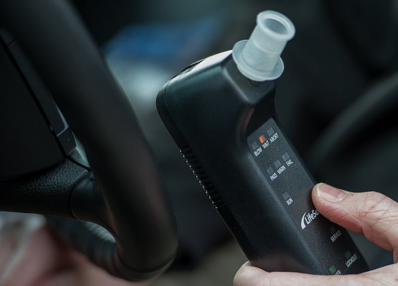 Bill Chastain, State Director with LifeSafer, demonstrates a breath alcohol ignition interlock device during a "Drive Sober or Get Pulled Over" press conference announcing a holiday crack-down on drunk and drugged driving December 17, 2013 in Washington, DC. AFP PHOTO/Paul J. Richards