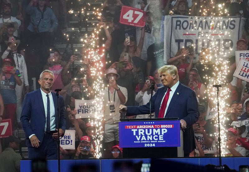Republican presidential nominee and former U.S. President Donald Trump speaks during a rally as former independent presidential candidate Robert F. Kennedy Jr. looks on in Glendale, Arizona, U.S., August 23, 2024.