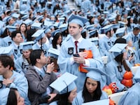 A group of students in light blue academic robes and caps.