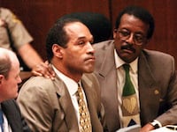 Lead defense attorney Johnnie Cochran puts his arm on O.J. Simpson’s shoulder during the football star’s murder trial.