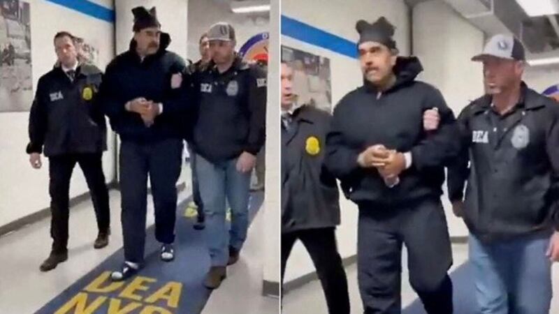 Nicolas Maduro in a blue top and handcuffed with a DEA agent on each side