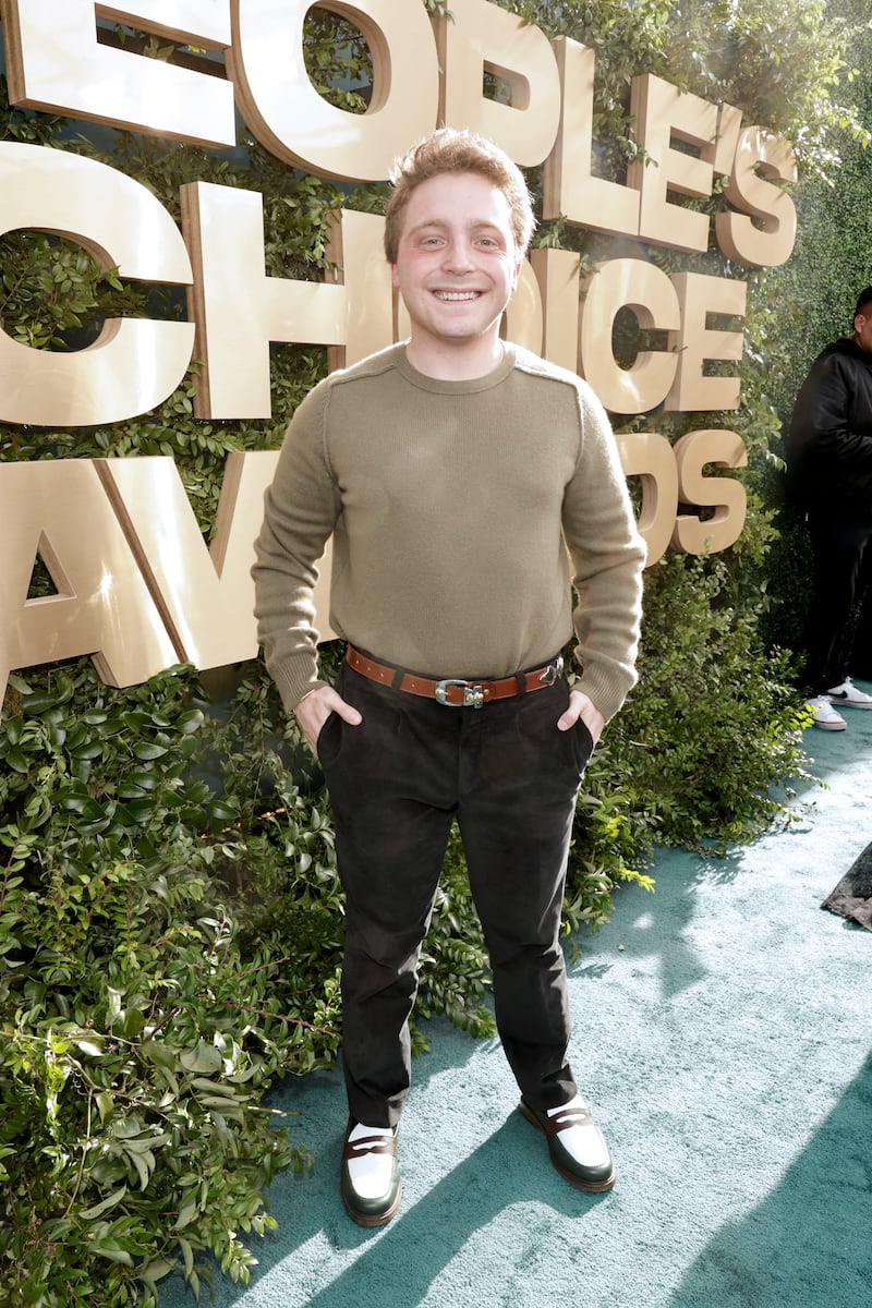 Jake Shane, wearing an army-green Henley and black jeans, arrives at the 2024 People's Choice Awards held at Barker Hangar on February 18, 2024, in Santa Monica, California.