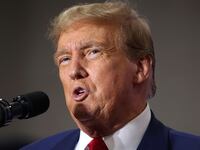 Former President Donald Trump speaks into a microphone.